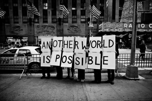 activists holding a sign saying 'another world is possible'